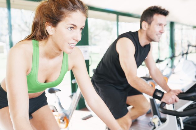 Athletes using the stationary bicycle in a gym