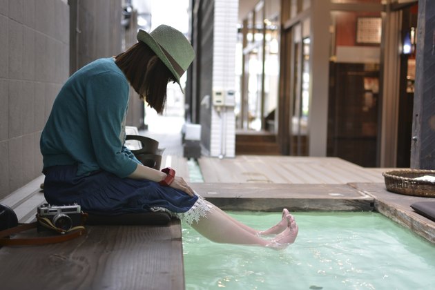 Relax woman looking at barefoot in the foot bath.