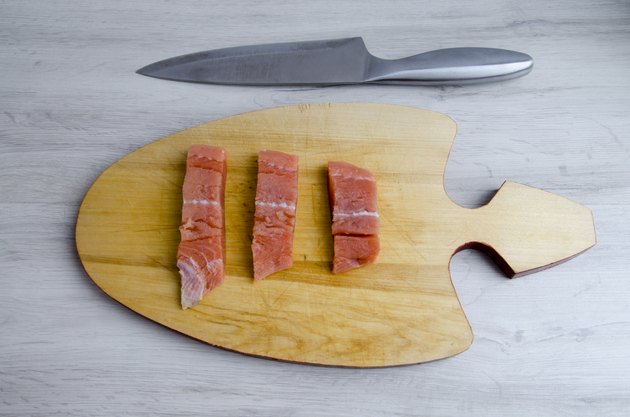 The pieces of salmon on a cutting Board and knife