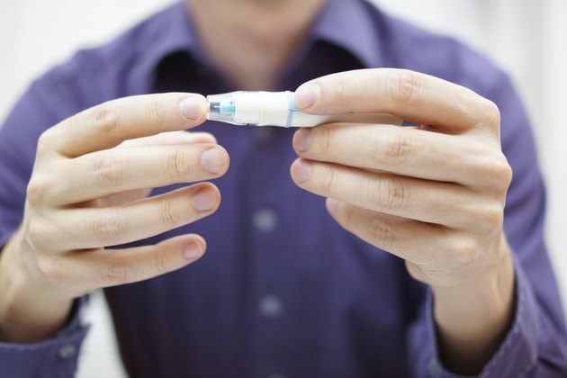 Closeup of young man using checking level of blood sugar