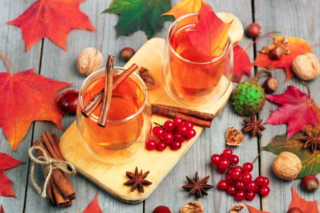 Autumn hot beverage in a glass with fruits and spices