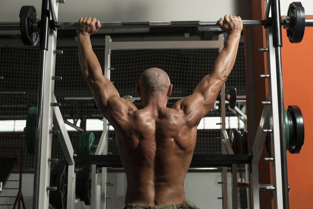 Bodybuilder Doing Heavy Weight Exercise For Shoulder