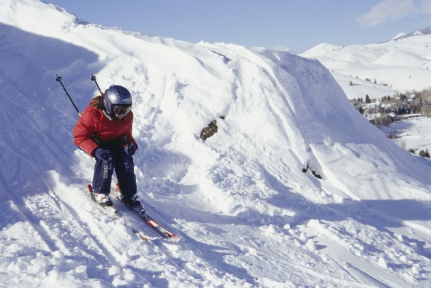 Girl (12-13) skiing down ski slope in mountains