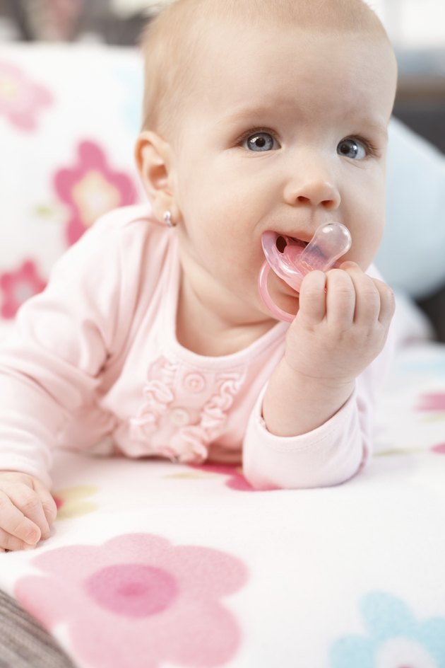 Beautiful baby girl playing with dummy