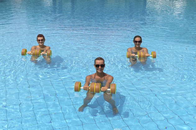 Happy active fitness people doing exercise with aqua dumbbell