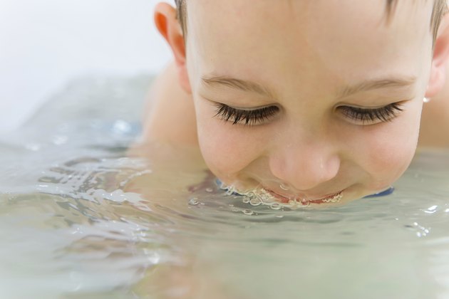 Happy little boy bathing in bathtub