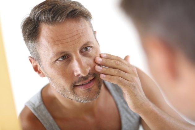 Man in bathroom looking at mirror