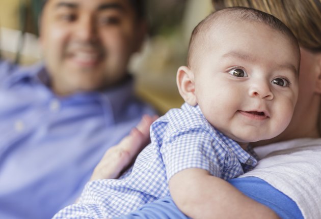 Happy Attractive Mixed Race Couple Burping Their Son