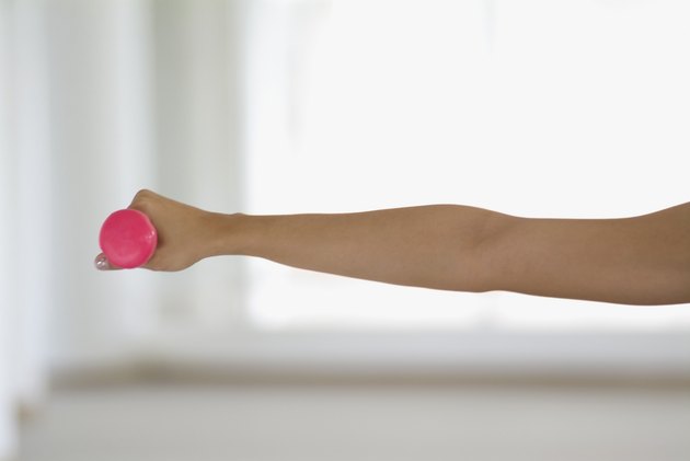 Outstretched arm holding pink weight, close-up