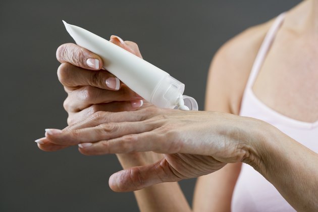 Middle-aged woman applying hand cream