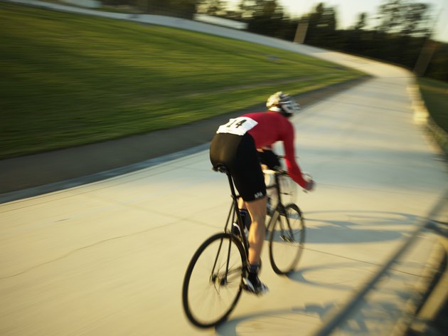Cyclist on velodrome track, rear view