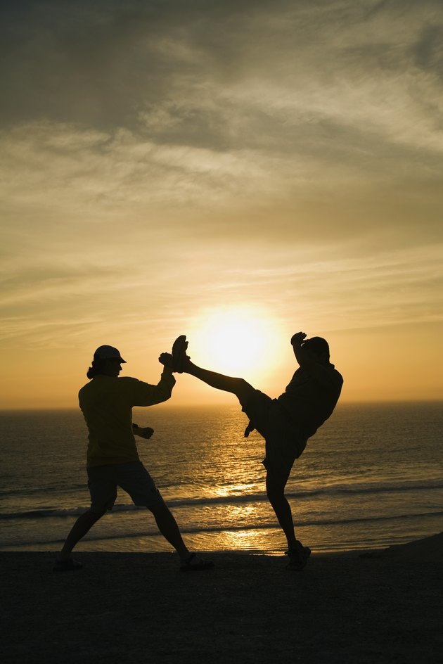 Two men fighting on a beach