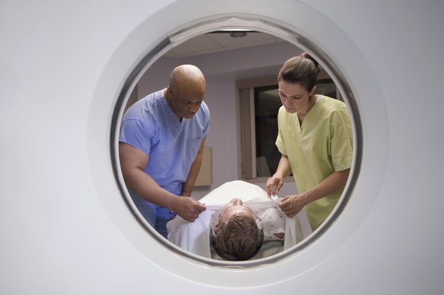View of technicians preparing patient for MRI, as seen through the MRI machine