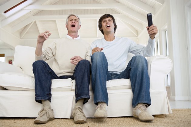 Surprised father and son watching television