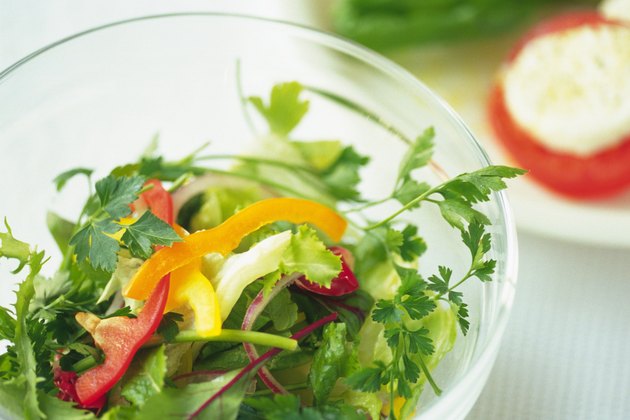 Mixed salad leaves in bowl, another salad visible in background, Differential Focus