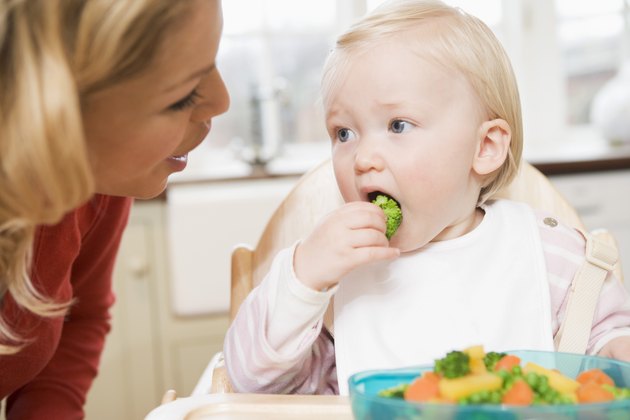 Mother watching child eating