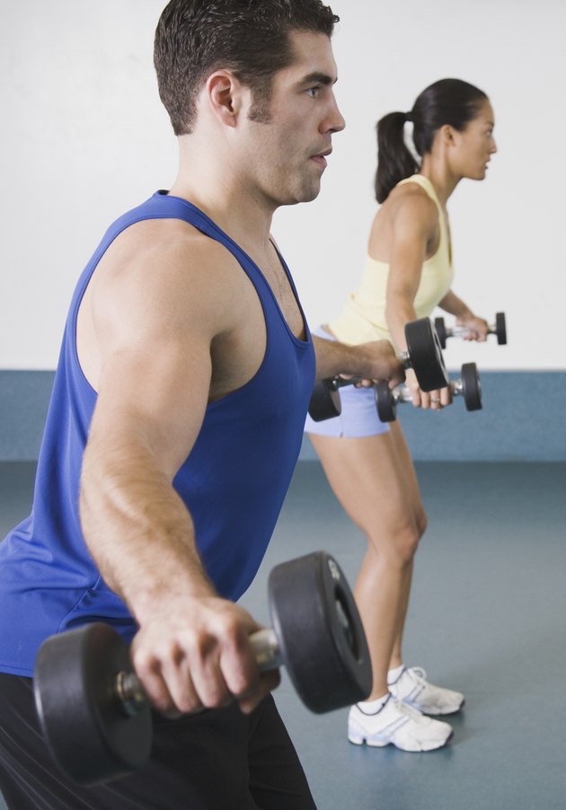 Man and woman lifting weights at gym