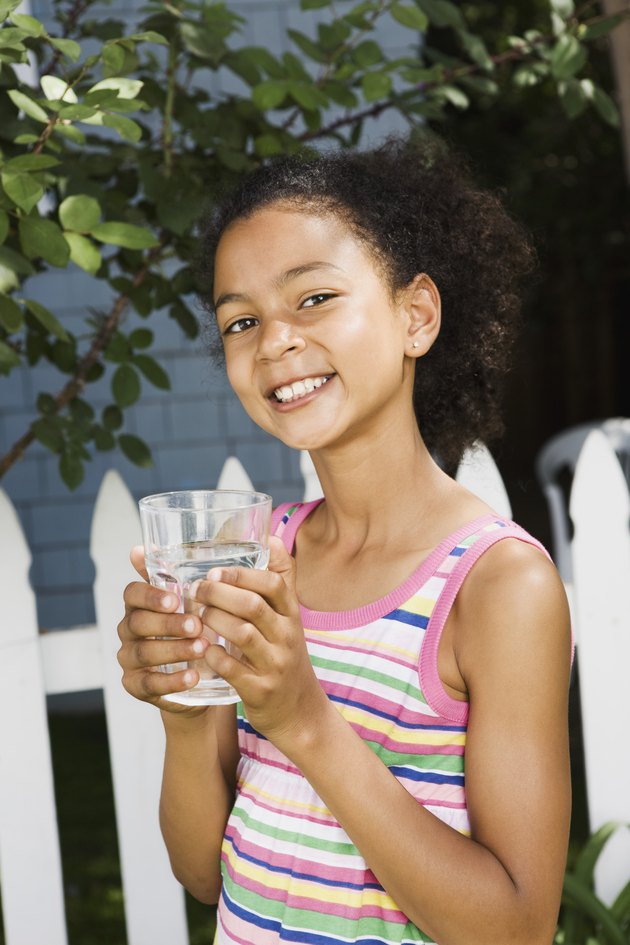 Smiling girl holding water glass