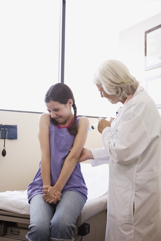 Doctor injecting preteen girl with needle