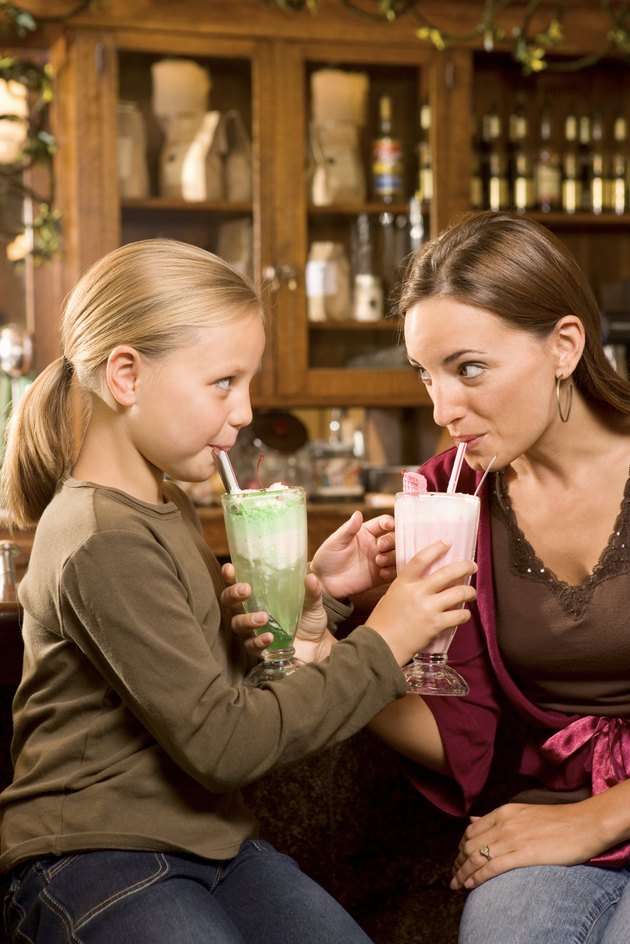 Mother and daughter drinking milkshakes