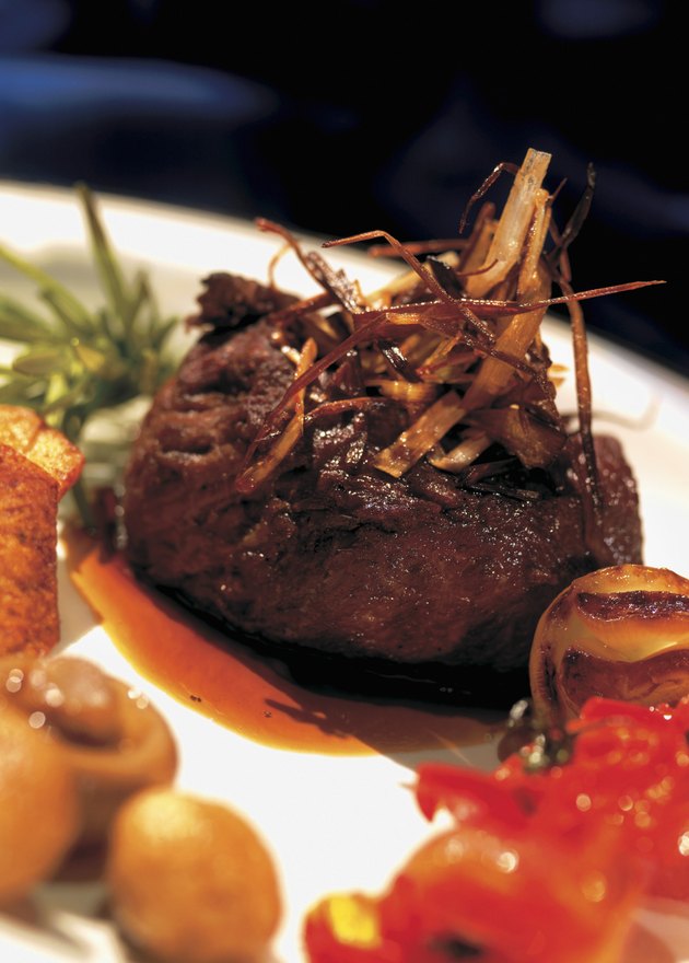 close-up of a piece of cooked meat garnished with fried onions