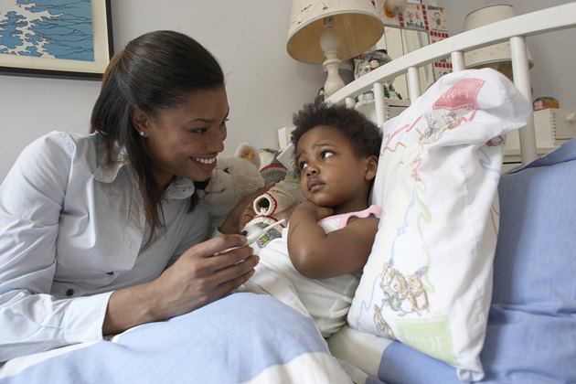 Mother checking temperature of daughter (21-24 months) with thermometer