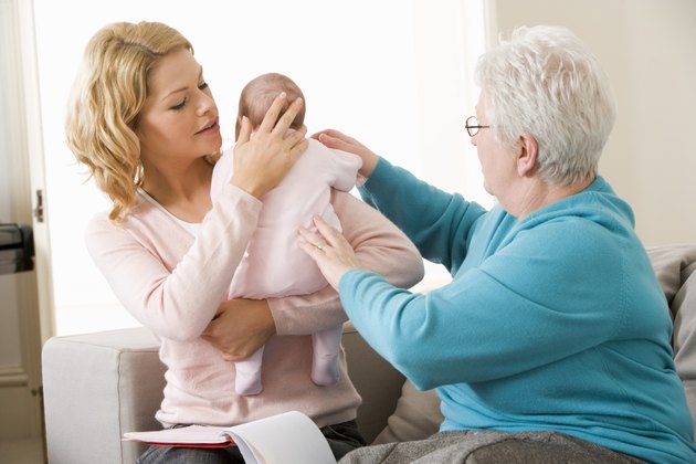 Home healthcare nurse helping mother and baby