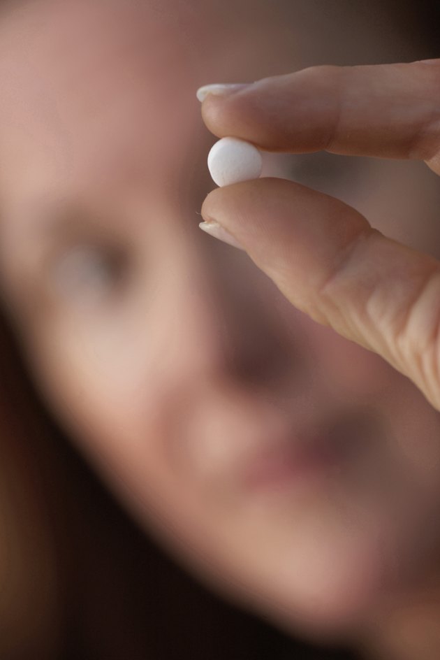 Close-up of a mature woman showing a pill
