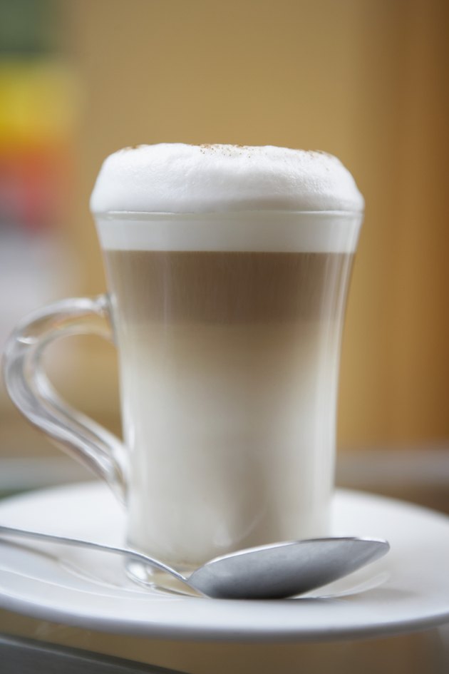 Close-up of a cappuccino on a saucer with a spoon