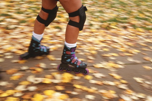 Person inline skating in park, autumn, low section