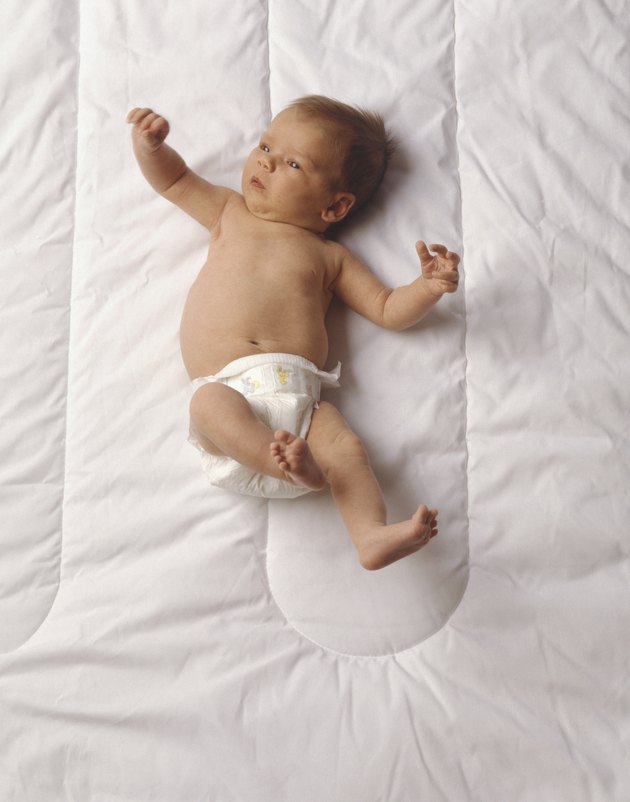Baby (3-6 months) lying on bed
