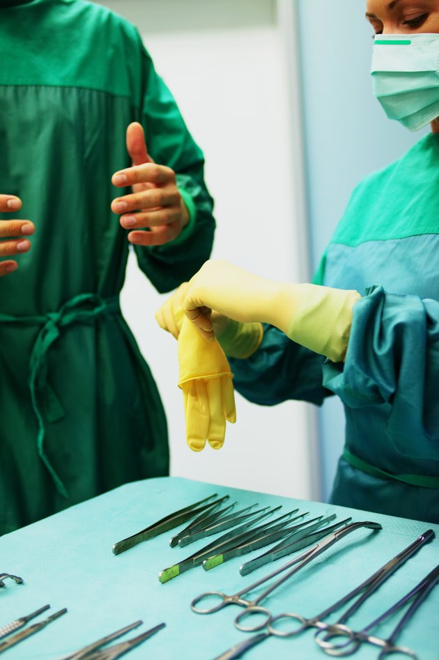 手术室工作人员穿着实习医生风云,一个帮助其他戴上手套