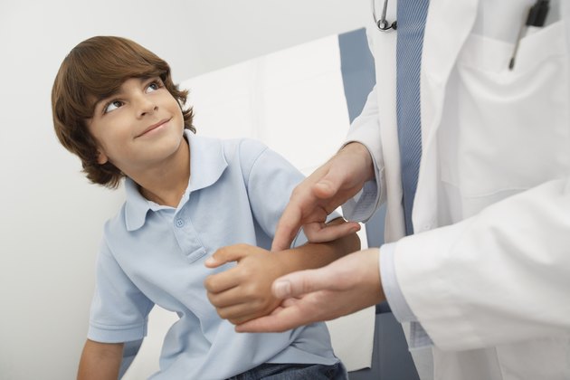 Doctor checking boys pulse