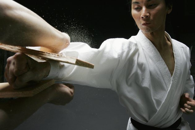 Player of karate, breaking plank