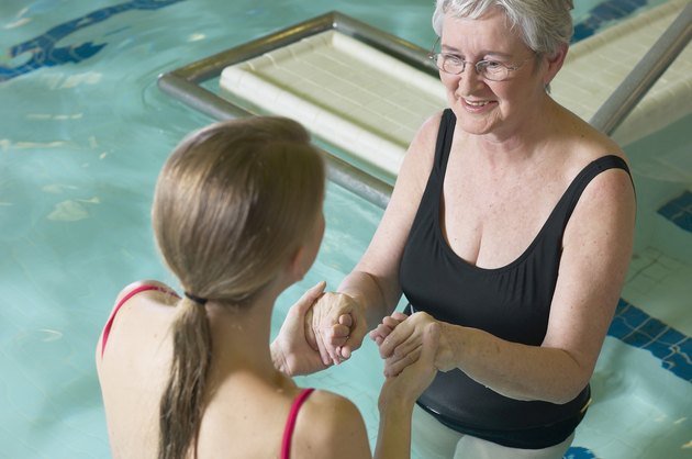 Woman in water therapy with therapist