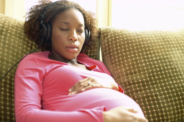 Pregnant woman listening to headphones