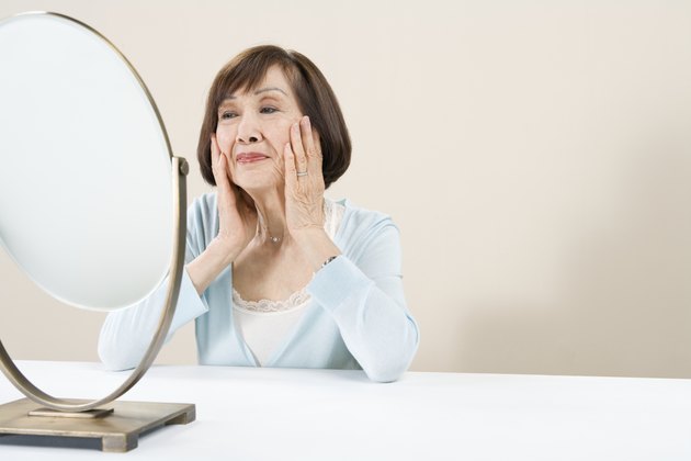 Woman sitting at table looking in mirror
