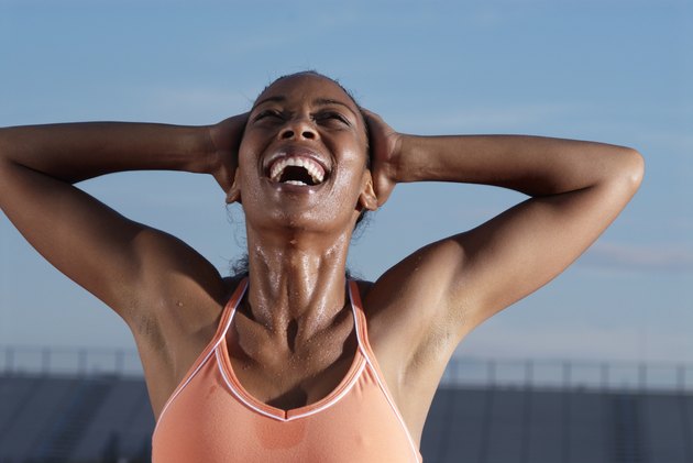 Young female athlete with hands behind head laughing