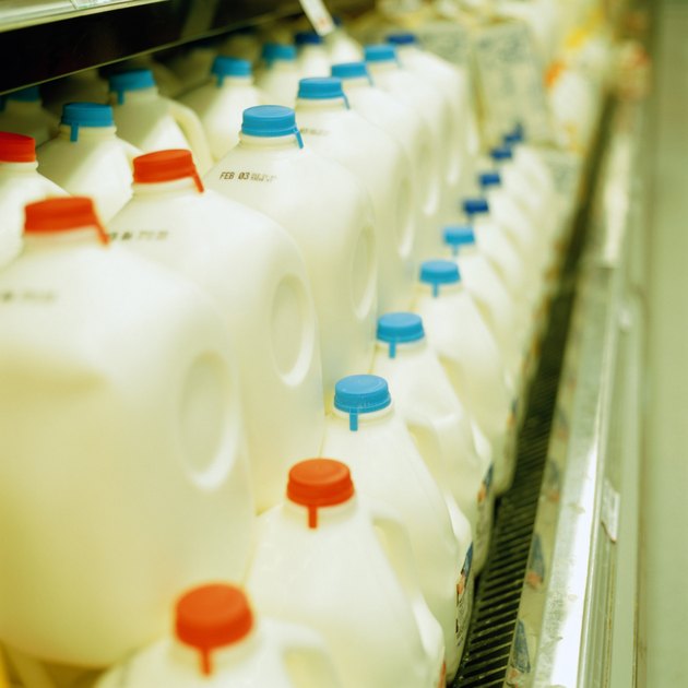 Rows of plastic milk containers in supermarket