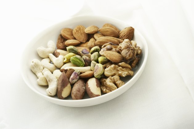White bowl containing a variety of nuts, close up