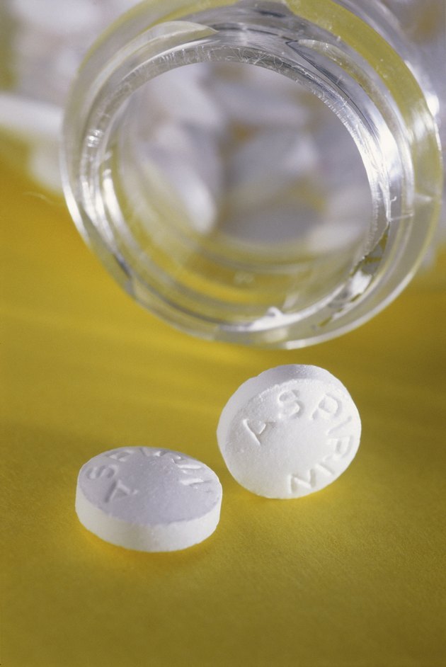 Close-up of an open bottle of aspirin tablets