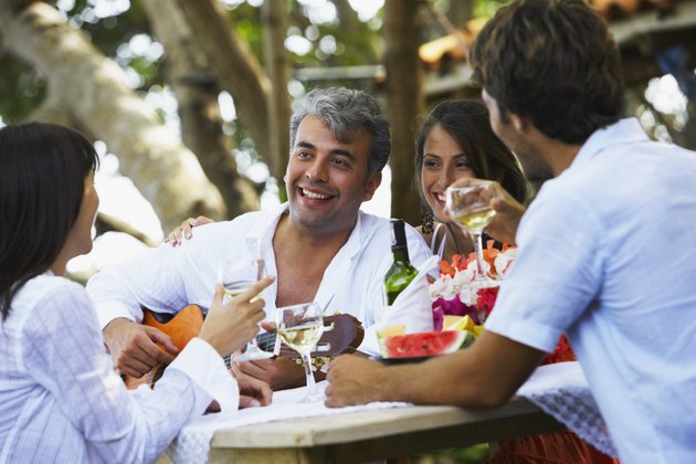 South American man playing guitar for friends