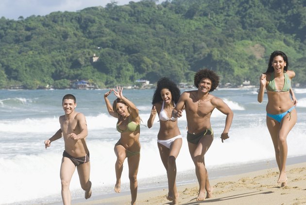 Multi-ethnic friends running on beach
