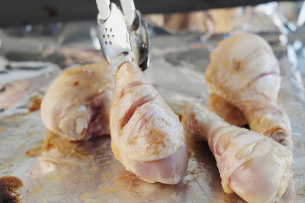 Broiling chicken drumsticks, close up