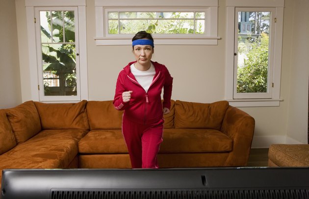 Woman exercising in front of television