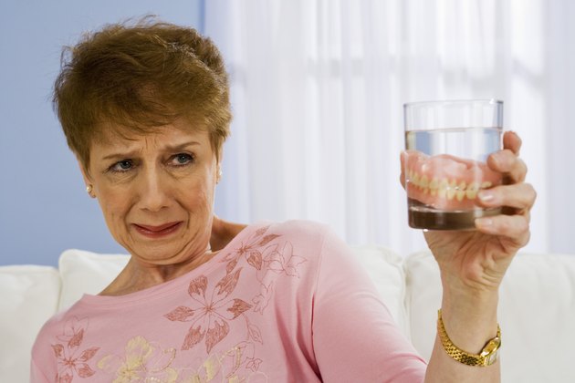 Woman with dentures in glass of water