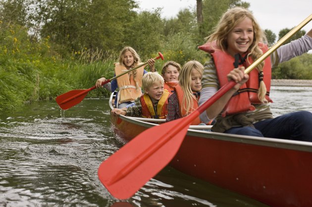 Siblings canoeing on river