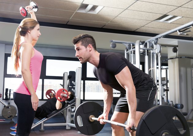 Gym weightlifting couple workout barbell dumbbell