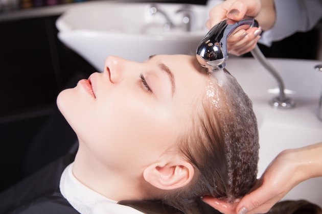 Hairdresser washing a woman's blond hair