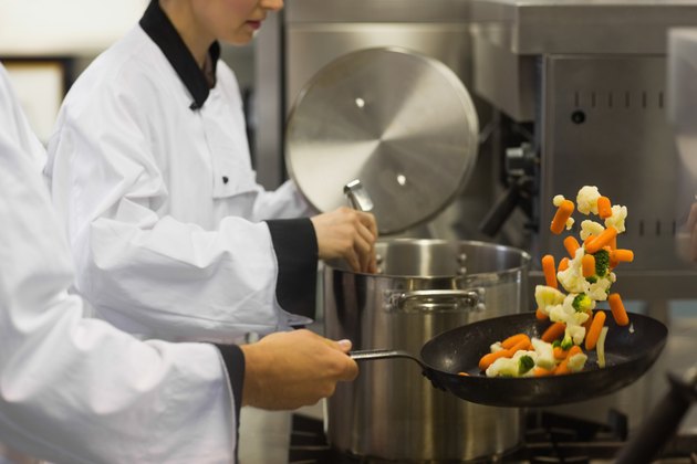 Two chefs working in a busy kitchen